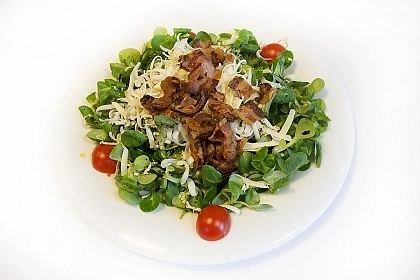 Ensalada templada de canónigos con papada ibérica y queso de cabra